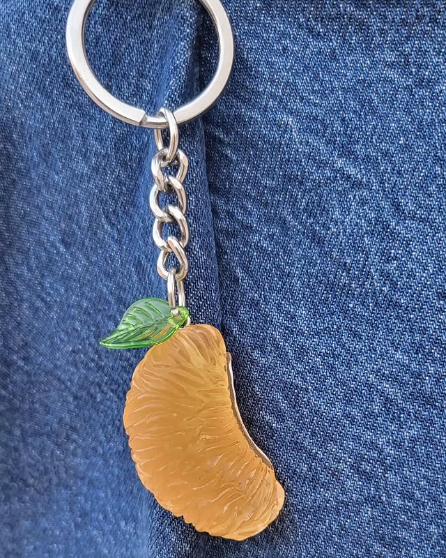 Orange slice keychain charm on denim